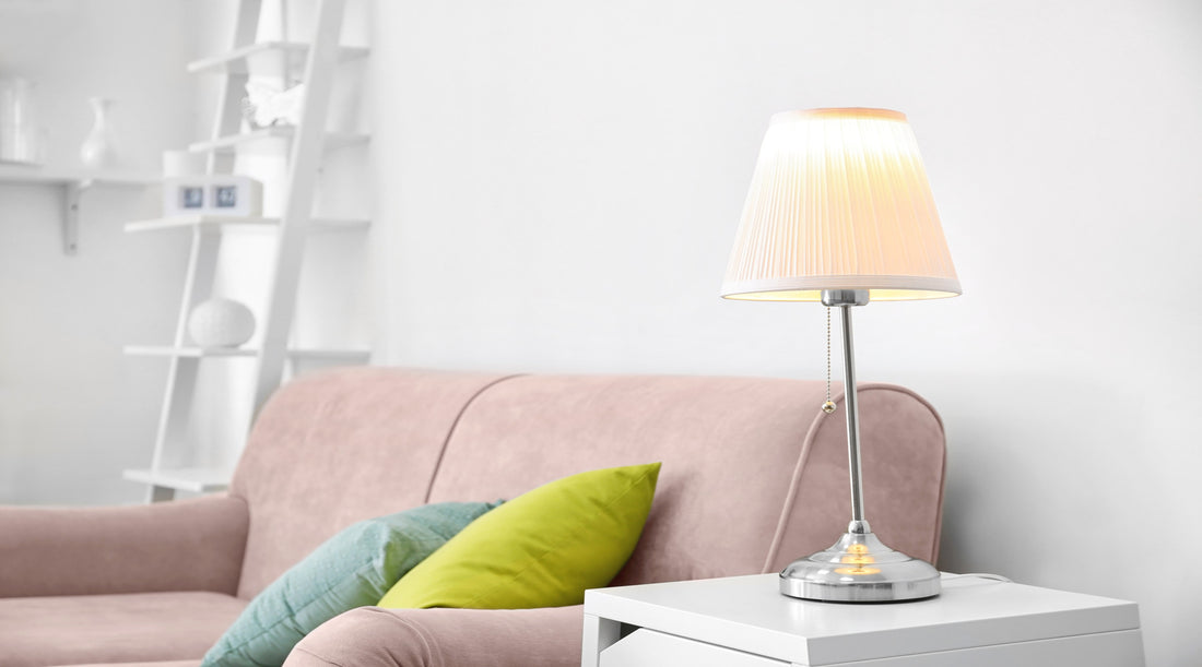 A21 LED bulb used in elegant table lamp next to cozy pink sofa