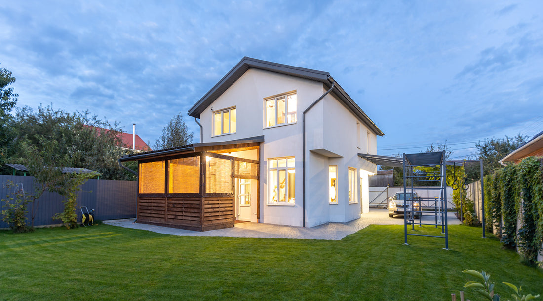 Exterior view our modern white house illuminated with outdoor lighting