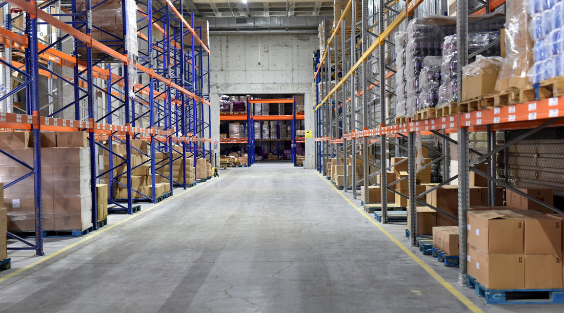High bay lights illuminating rows of shelves with boxes in modern warehouse