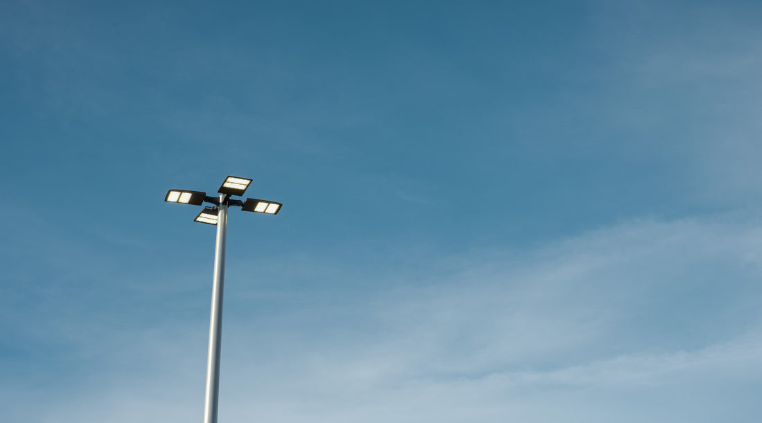 LED parking lot lights shown mounted to pole with sky in the background