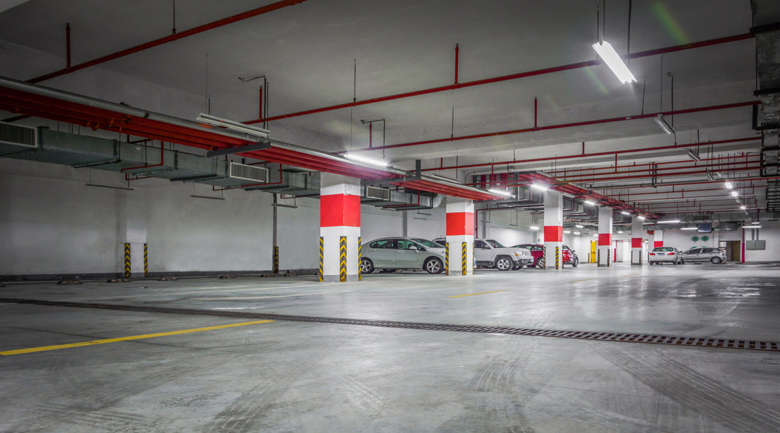 Linear fluorescent strip light fixtures illuminating empty parking garage