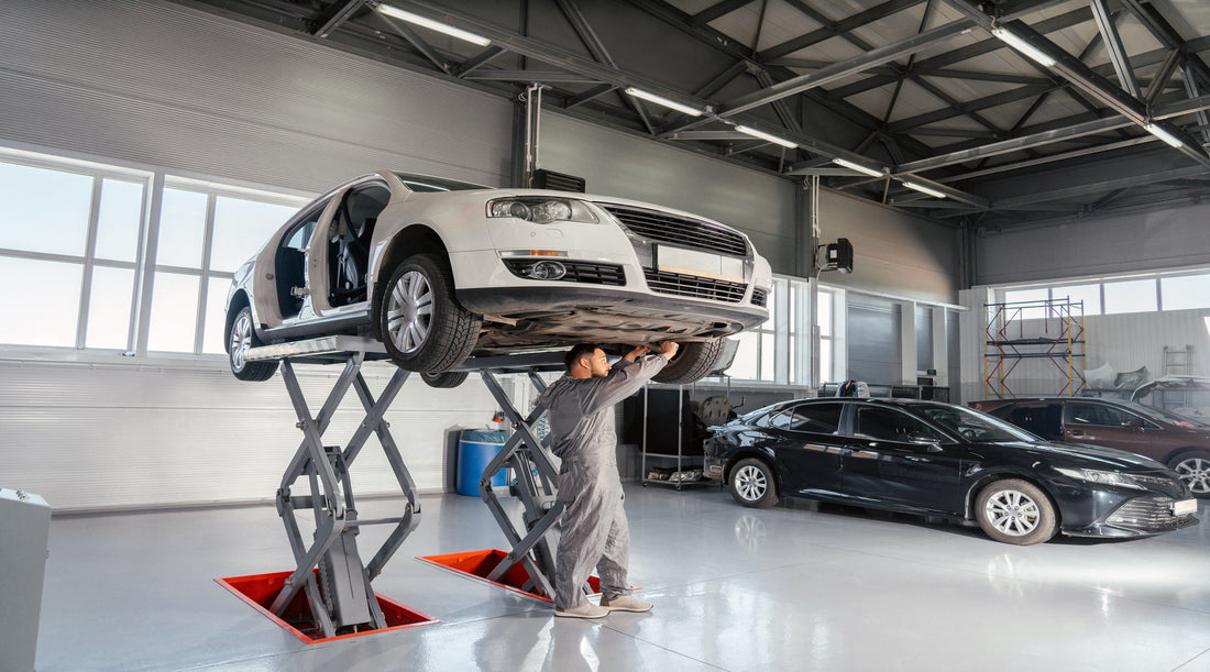 Overhead lighting installed in garage where mechanic is repairing a car
