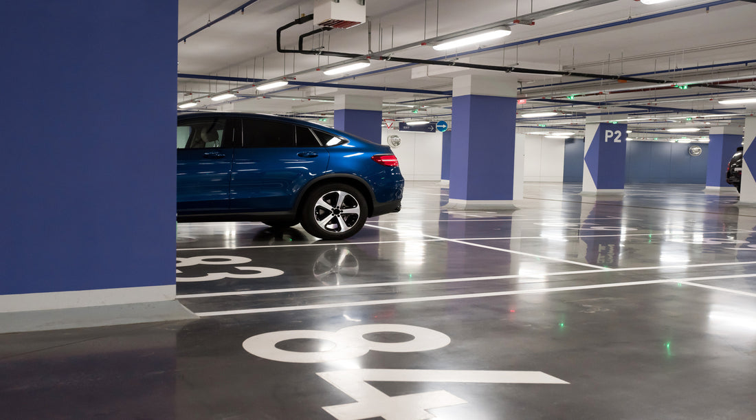 Vapor tight lighting shown in parking garage with blue car