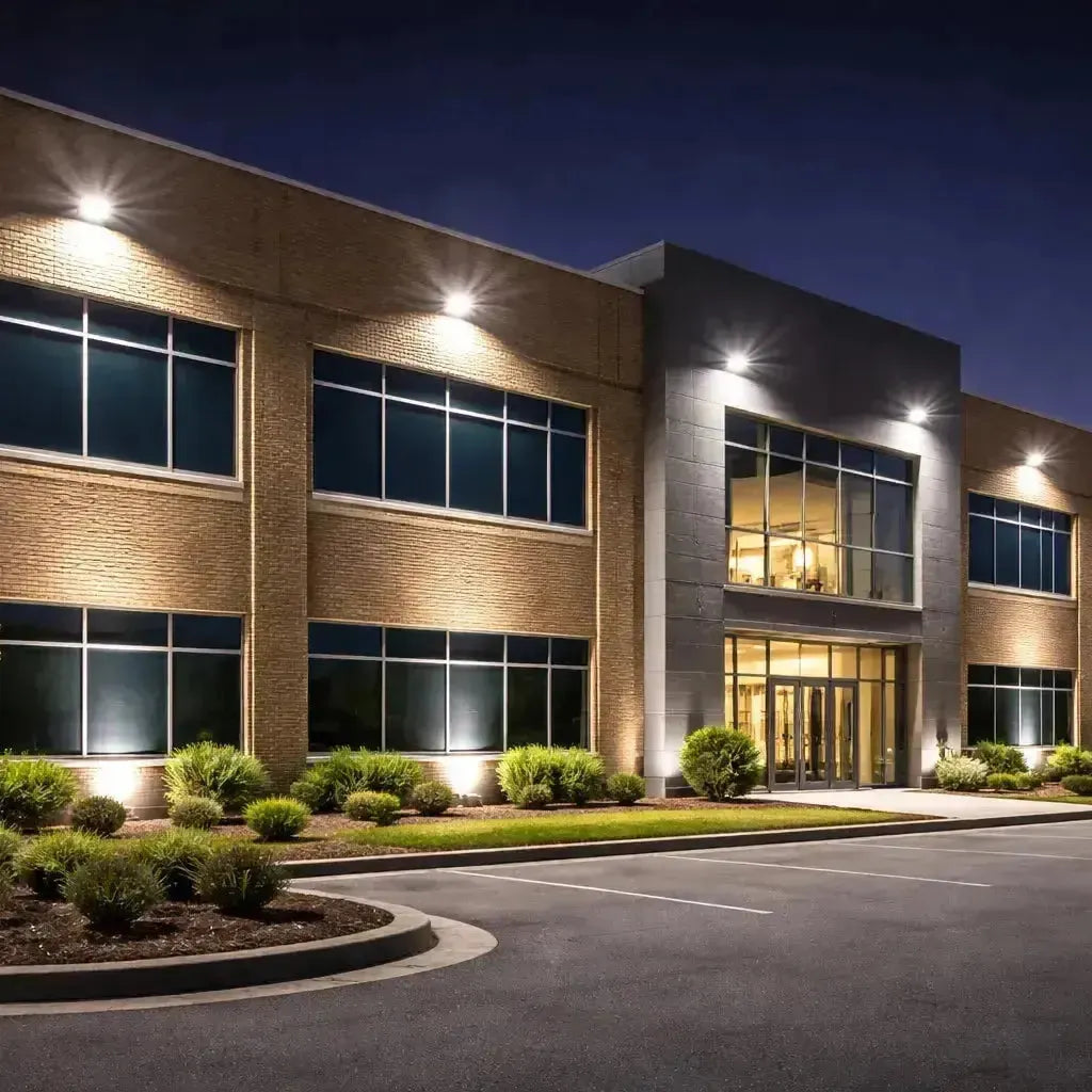 LED flood lights shining upward to illuminate a commercial building facade at night