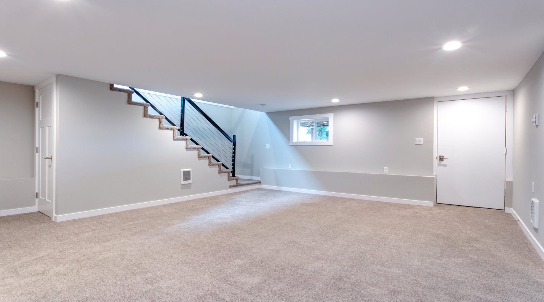 Basement lighting installed in large spacious basement with staircase