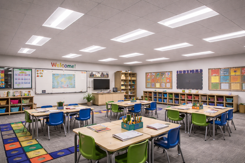 Center basket LED troffer lights illuminating a commercial classroom with a suspended ceiling grid
