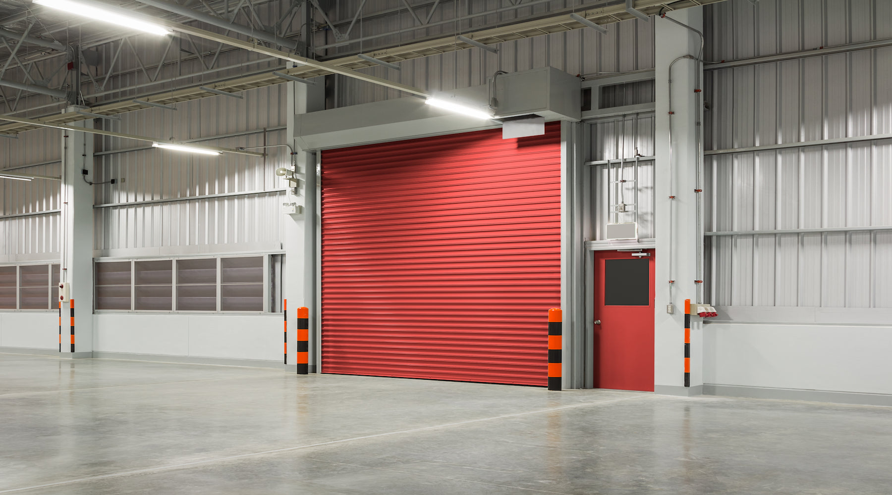 Garage lighting installed in large garage with red roller door