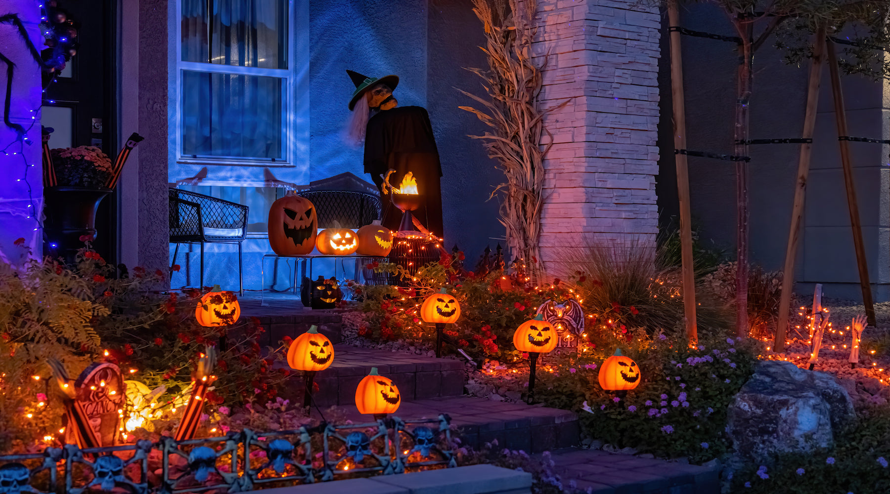 Halloween lighting shown installed on house at night illuminating halloween decorations