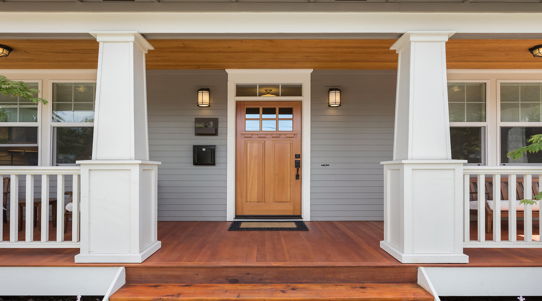 Porch lighting installed on beautiful covered front porch with wooden door