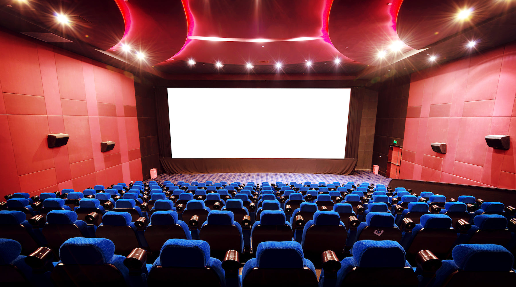 Theater lighting shown installed in an empty movie theater with red walls and blue seats