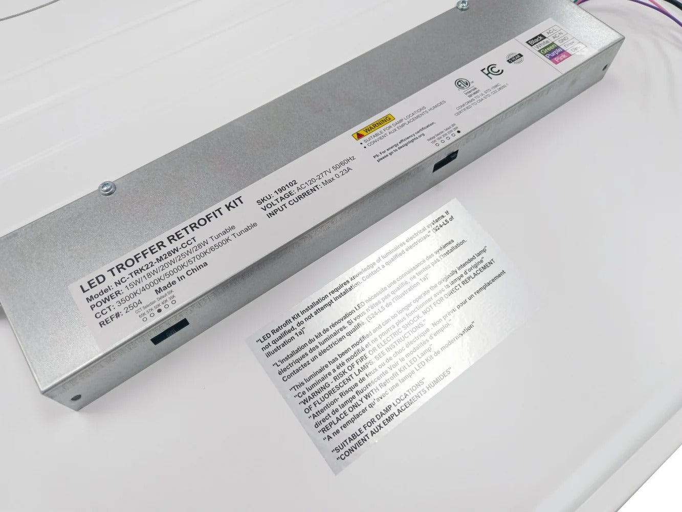 Tight close-up of the 2x2 LED troffer retrofit kit electrical/driver box highlighting the side CCT and wattage selectable slide/dip switches and the lead-wire exit (purple/pink/black visible at the end); 15/18/20/25/28W, 1,950–3,500 lm, 3500K/4000K/5000K/5700K/6500K, 0–10V dimming, 120–277V.