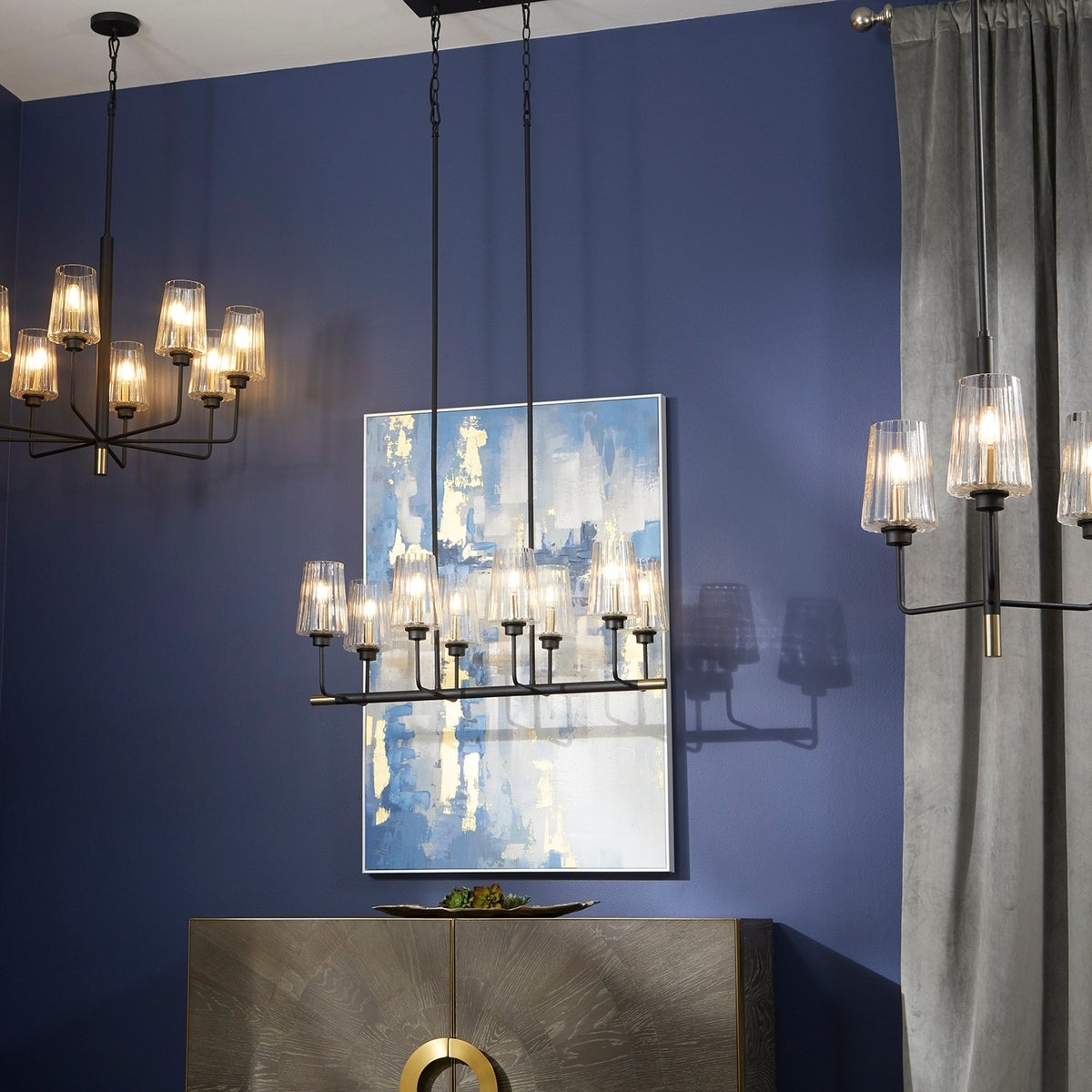 Bathroom chandelier with tulip-shaped, clear fluted glass shades. Minimalist-inspired design with soft-angular curves. Adjustable chain/stem hung suspension system. Suitable for bathrooms, outdoor kitchens, and covered patios. 19"W x 20"H. 2-year warranty.