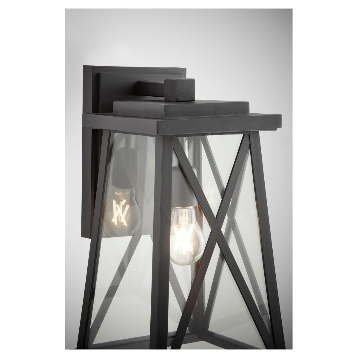 Black Outdoor Wall Light with X-brace design and warm glow cascading from the fixture. UL Listed for wet locations. 100W, 1 bulb, medium E26 base. 9.25"W x 16.25"H x 9.75"E. 2-year warranty.