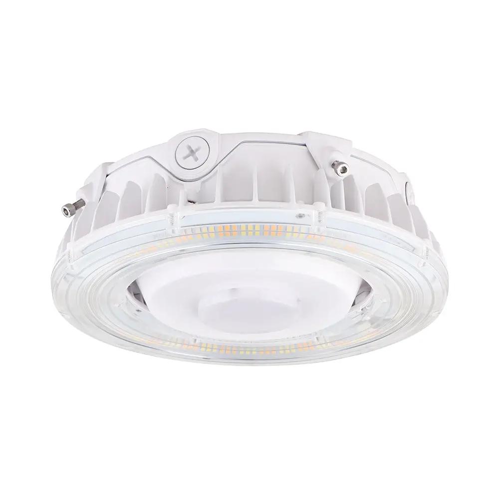 Ceiling Light Canopy: A close-up of a white LED light fixture with a circular design and a screw. Provides 6785-7700 lumens of CCT tunable white light. Weatherproof (IP65) and UL safety certified. Ideal for replacing metal halide or fluorescent fixtures.