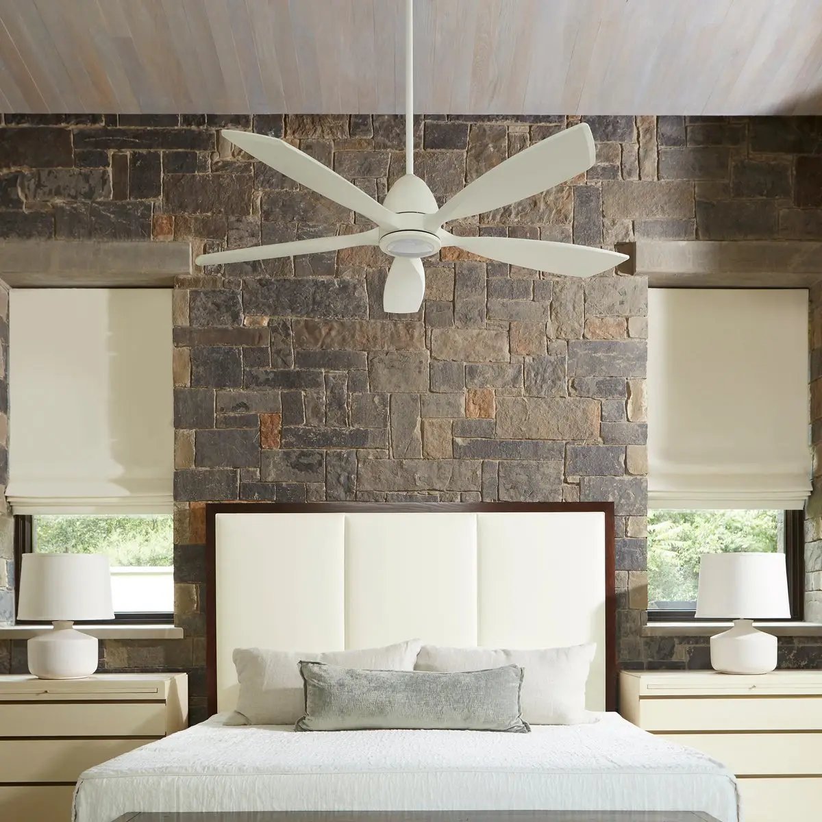 Contemporary Ceiling Fan with Light in a Bedroom, featuring a gentle twist design and soft lines. 56-inch blades with a 16-degree pitch and 6-speed DC motor. Integrated LED lighting for added comfort. Oiled Bronze, Satin Nickel, or Studio White finish. UL Listed for Dry Locations. Limited Lifetime Warranty.