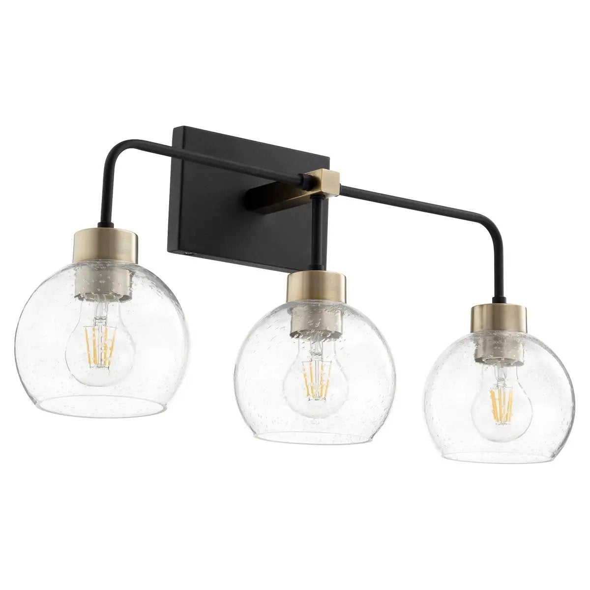 Contemporary vanity light with three clear glass globes and aged brass-noir finish, emitting ambient glow from eight candelabra light sources. Suitable for modern-industrial or minimalist-loft settings, both indoors and outdoors.