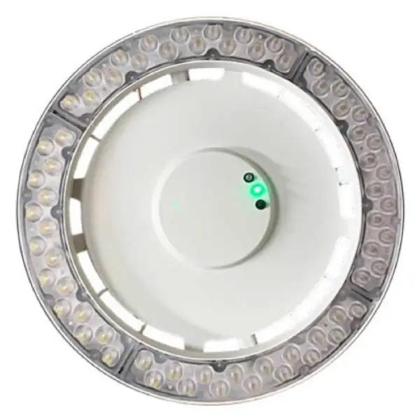 Bottom view of an emergency high bay lighting fixture with the test/charge indicator illuminated (green), showing the polycarbonate frosted lens for a 100° beam; 30W, 4,000 lumens, 80+ CRI, IP66 rated, multi-voltage 120–277V / 347V / 480V operation.