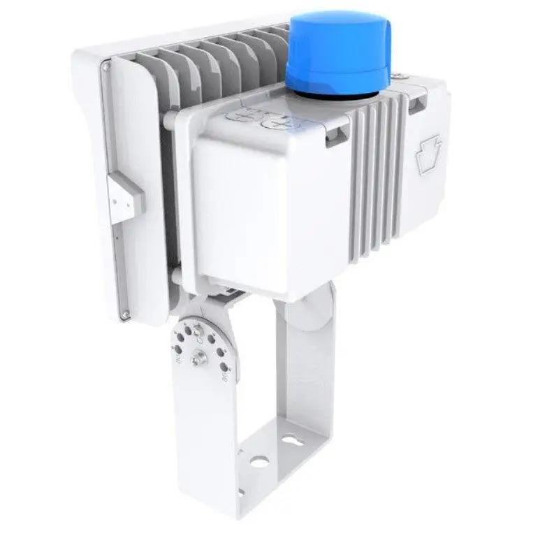 Angled rear view of the white LED floodlight highlighting the top-mounted blue photocell, heat-sink body, and tempered glass lens with slip-fitter/trunnion mount; 100–140W, 14,500–19,600 lm, 3000K/4000K/5000K, 80+ CRI, 0–10V dimming, IP65, 120–277V.