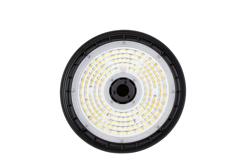 Underside view of the UFO high bay highlighting the lens surface and the center-mounted sensor receptacle/port for control accessories; 120–277V input with 0–10V dimming, selectable 150/200/240W output producing 22,500–36,000 lumens with 4000K/5000K/5700K CCT choices.