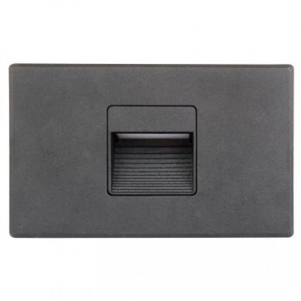 A black rectangular object with a square hole, suitable for outdoor and indoor applications. This Mini LED Step Light provides 125 lumens of soft white light, perfect for illuminating walkways, stairwells, patios, or decks. It offers dual mounting options and is dimmable. Rated for wet locations, this versatile step light from Lotus LED Lights measures 5"L x 3.31"W and comes with a 5-year warranty.