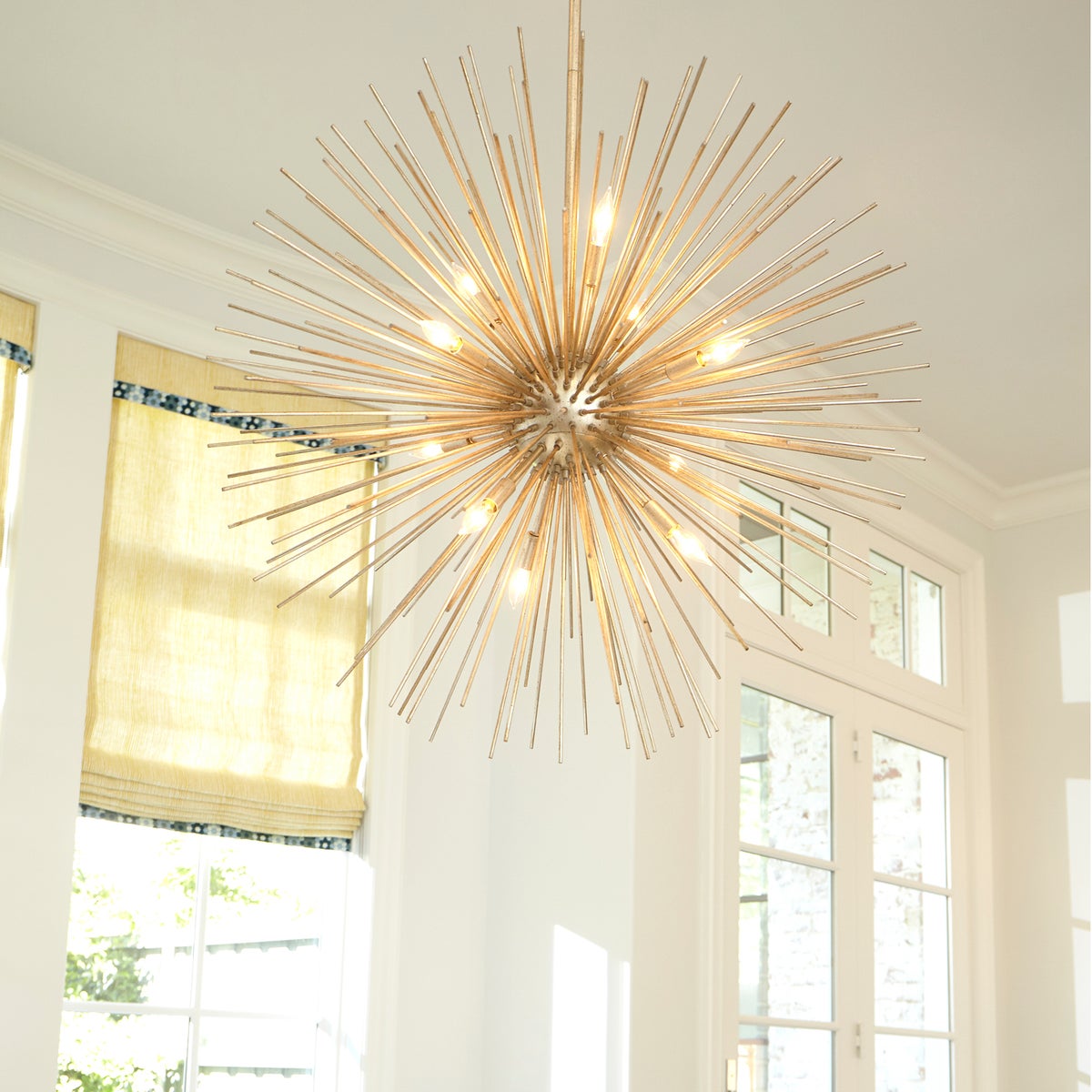 Modern Pendant Light: A gold chandelier with many lights, resembling an electrified dandelion. Creates a stunning focal point with burst of gold leaf spires and candelabra lighting.