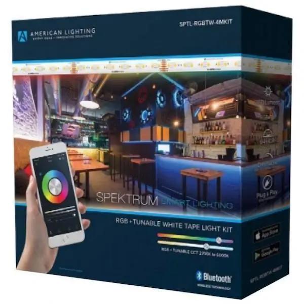 Smart LED Tape Light with a phone and a bar on a table. Control RGB/CCT lighting via phone app or remote. No hub or gateway required. Voice-command compatible with Google Home or Amazon Alexa. 7W, 24V, 360 lumens, dimmable, cULus Listed, IP65 Rated. Bluetooth, color changeable. Wet Location. 13.1' dimensions. 50,000 rated hours.