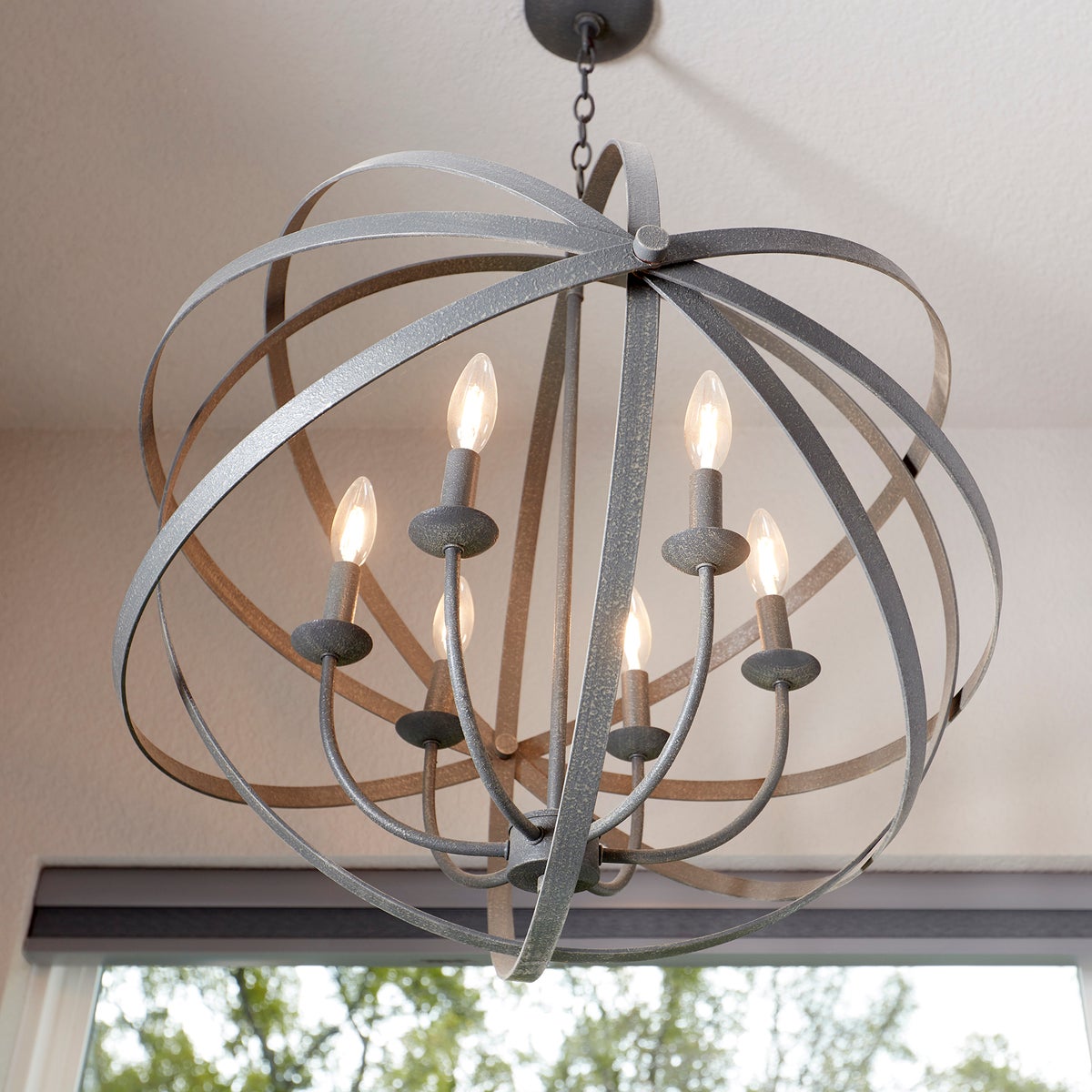 A modern sphere chandelier with strategically placed metal rings and candelabra lights, perfect for brightening up any atmosphere.