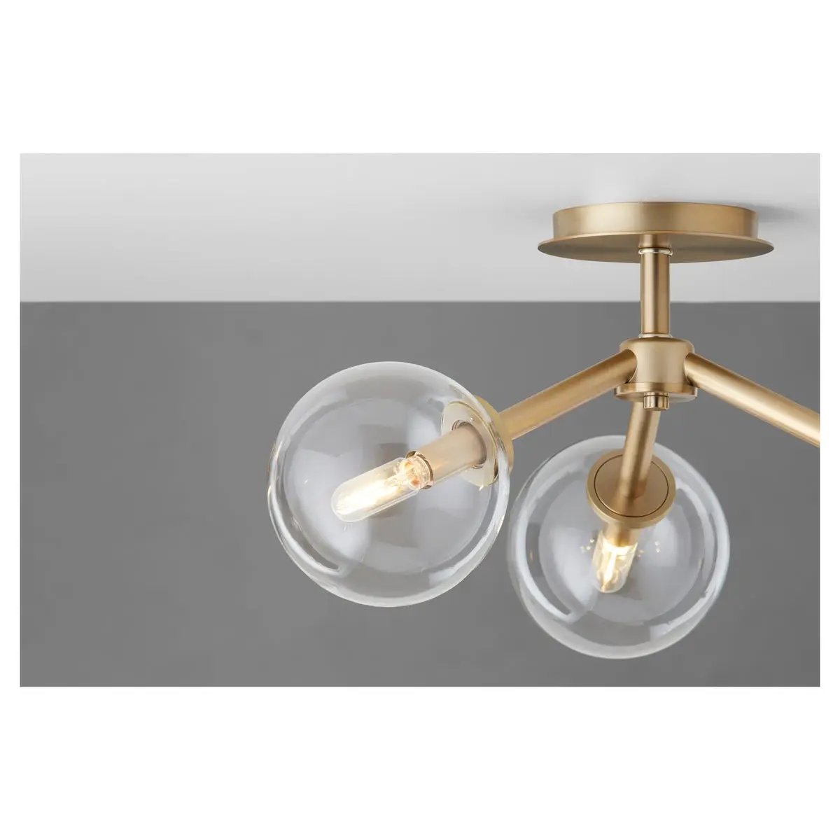 Sputnik flush mount ceiling light with two clear glass globes, aged brass frames. Mid-century modern appeal. 60W, 120V, 3 bulbs, dimmable. UL Listed. 21"W x 10.5"H. 2-year warranty.