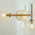 Sputnik Wall Sconce with clear glass domes on aged brass frames, adding mid-century modern appeal. Enhance your space with this brilliant design.