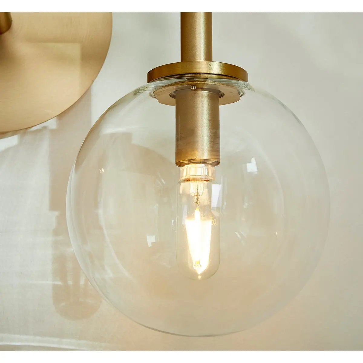 Sputnik Wall Sconce with clear glass domes and aged brass frames, adding mid-century modern appeal. Enhance your environment with this brilliant design.