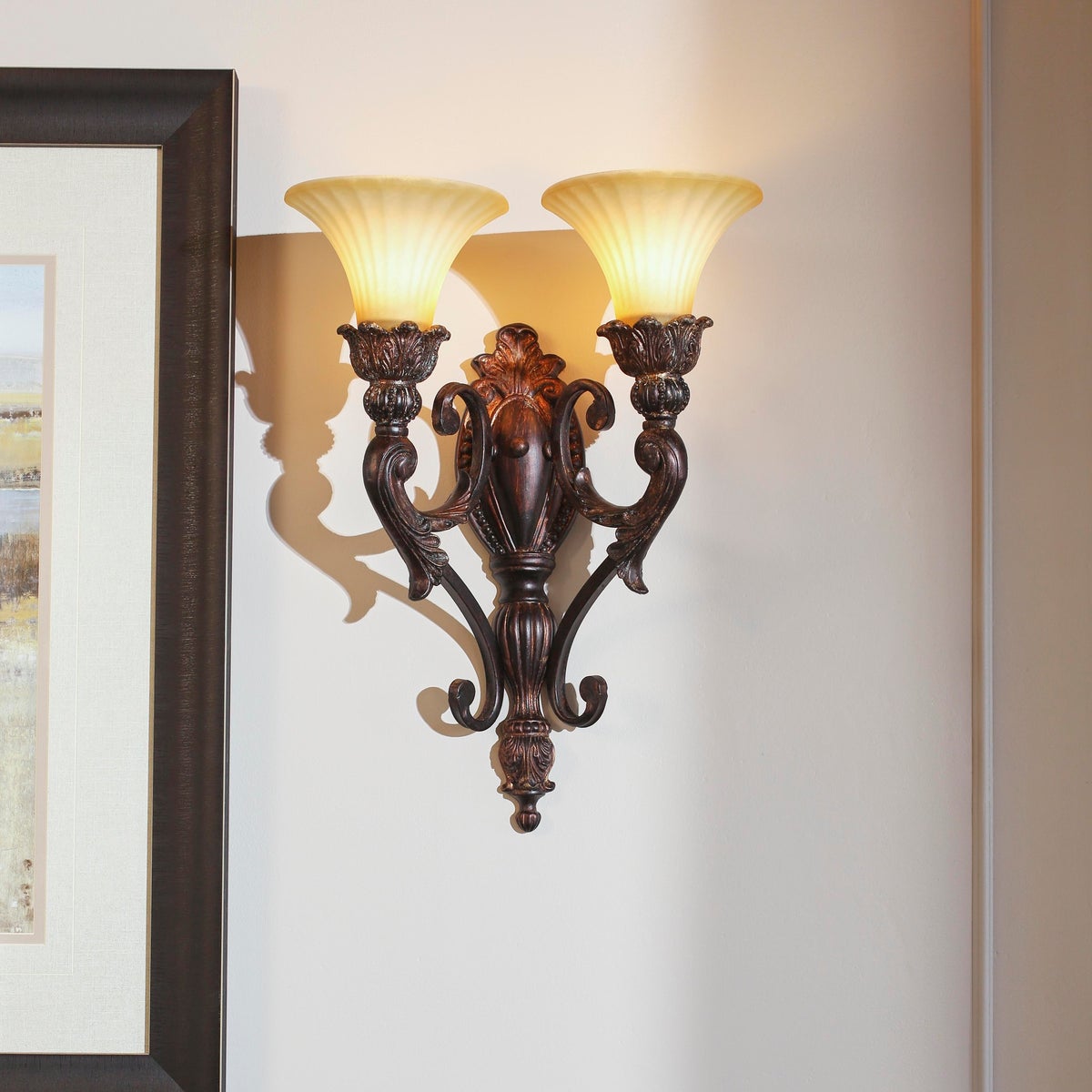 Traditional Wall Sconce with Corsican Gold Finish, featuring a cast structure and ornate wood and bronze detailing. Two shades provide elegant lighting.