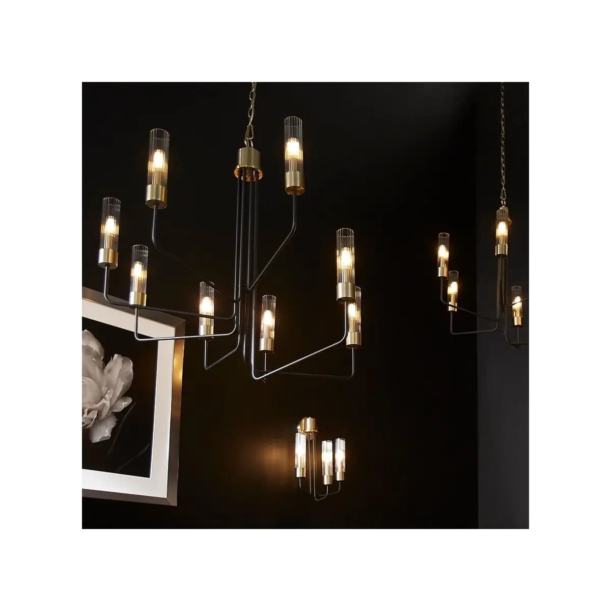 Transitional chandelier with minimalist design, aged brass and noir finish, and clear fluted glass shades. Perfect for mid-century modern spaces.