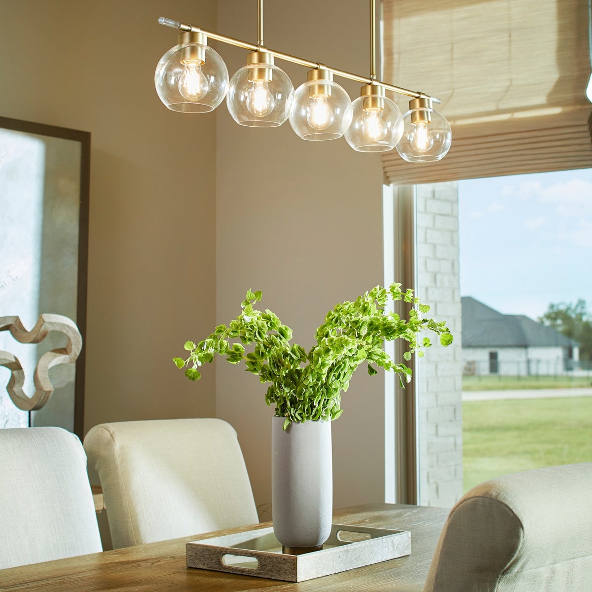 Transitional linear chandelier with rounded glass shades and aged brass finish. Thin acrylic accents add a mid-century touch. Perfect addition to any space.