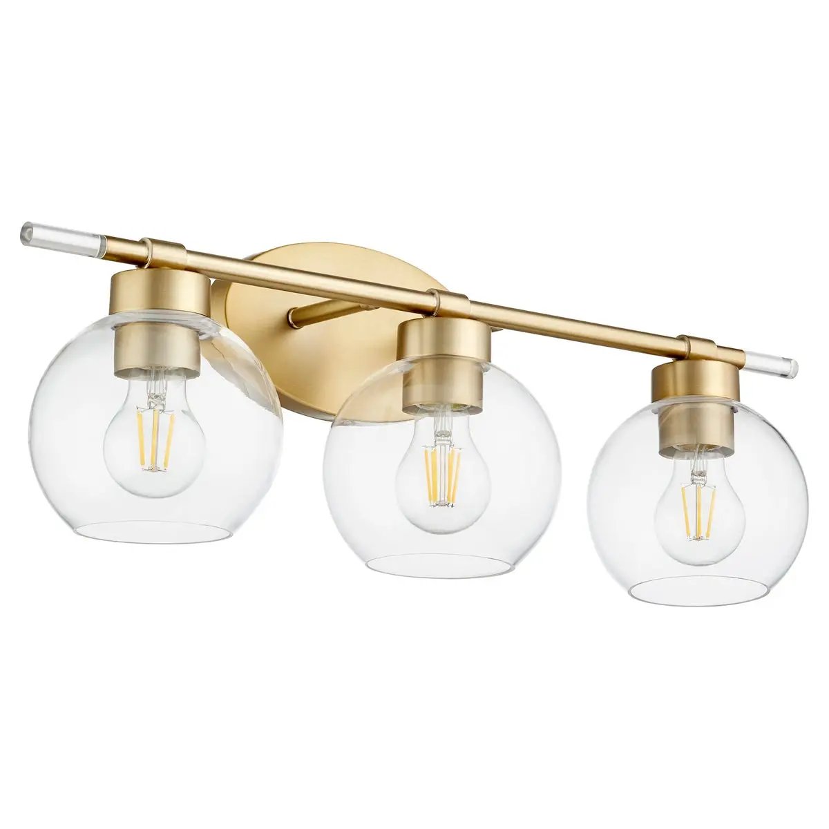 Transitional Vanity Light with clear glass bulbs, rounded silhouettes, and aged brass finish. Elevate your space with this mid-century inspired fixture from Quorum International. Perfect for any setting.