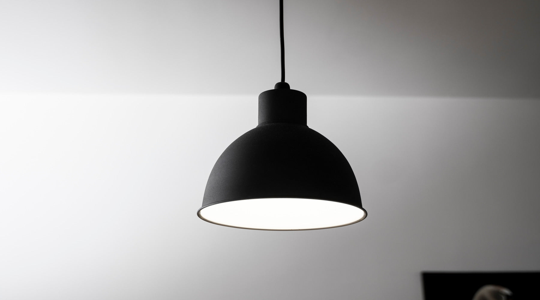A21 LED bulb used in black pendant light located in modern kitchen