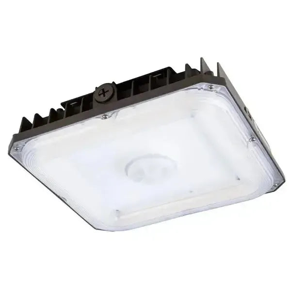 Angled underside view of CanoLux Series LED canopy light showing optical lens and integrated sensor receptacle for commercial canopy lighting controls