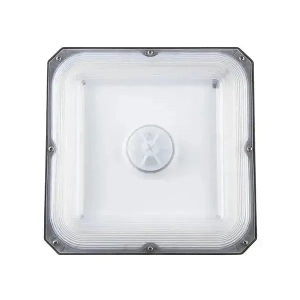 Bottom view of CanoLux Series LED canopy fixture showing sealed optical lens and sensor port for occupancy or daylight control integration