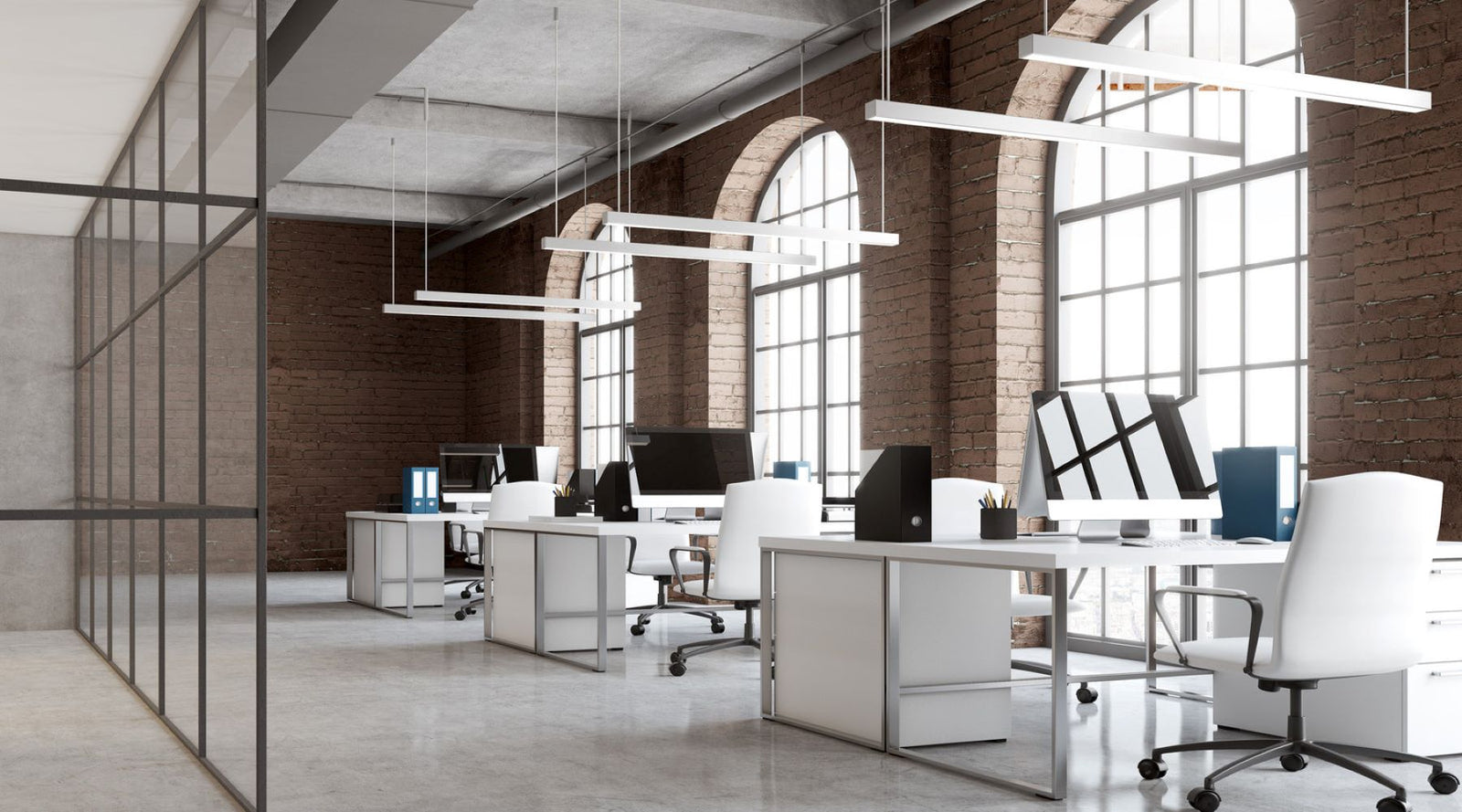 Commercial LED linear pendant lights illuminating an open office workspace with modern desks and computer stations