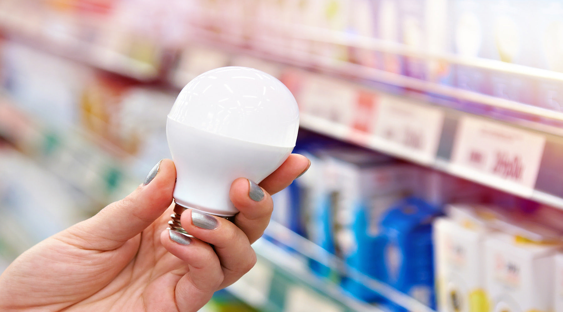 Energy saving LED bulb in hands of buyer at store
