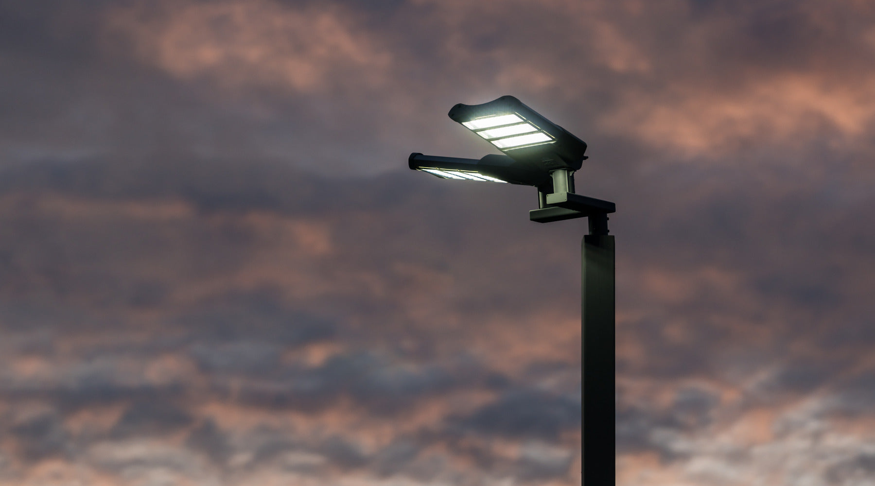 Flood lights shown mounted on top of pole during the morning twilight