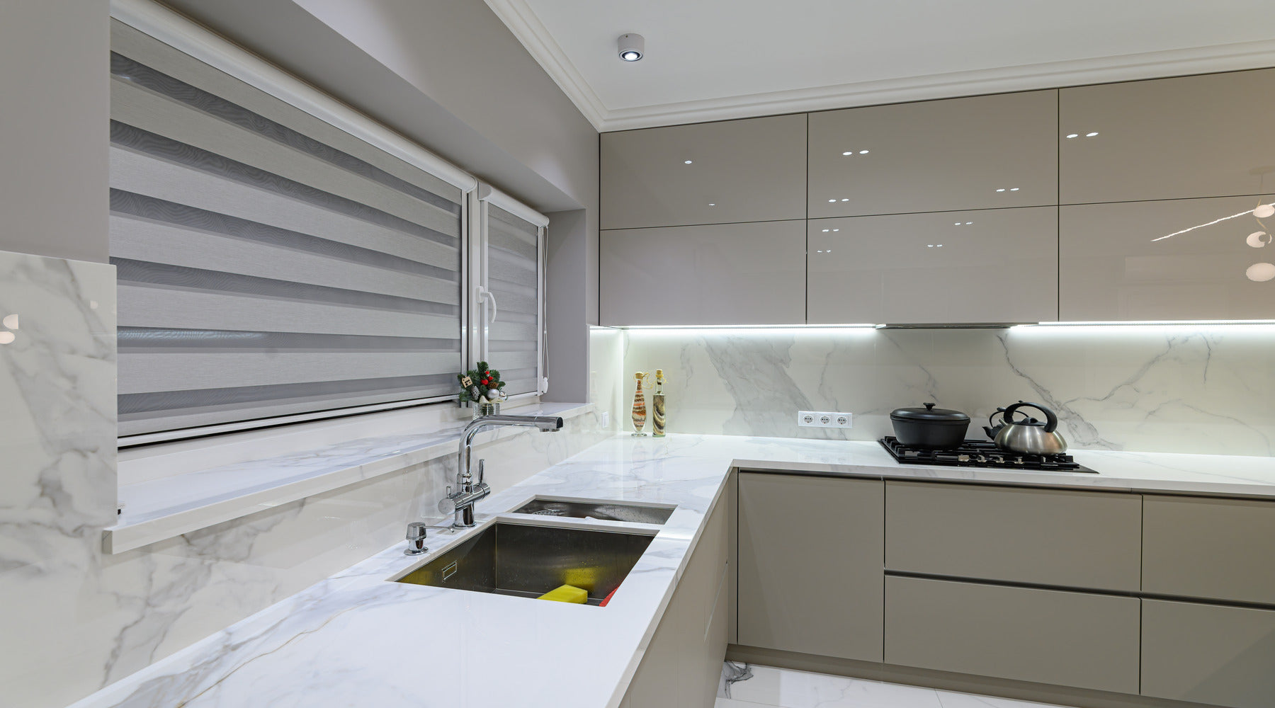 LED tape lights illuminating white marble countertops of luxury kitchen