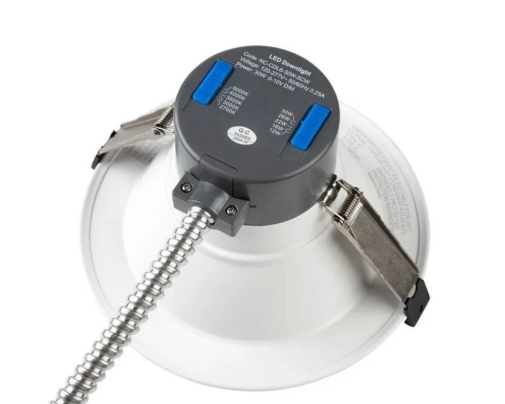 Angled top view of RecessEdge Series LED commercial downlight showing field selectable wattage and color temperature switches with housing clips and conduit connection