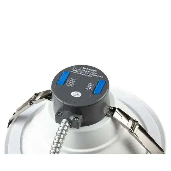 Close-up top view of RecessEdge Series LED commercial recessed downlight highlighting wattage and CCT selectable switches, mounting clips, and conduit entry point