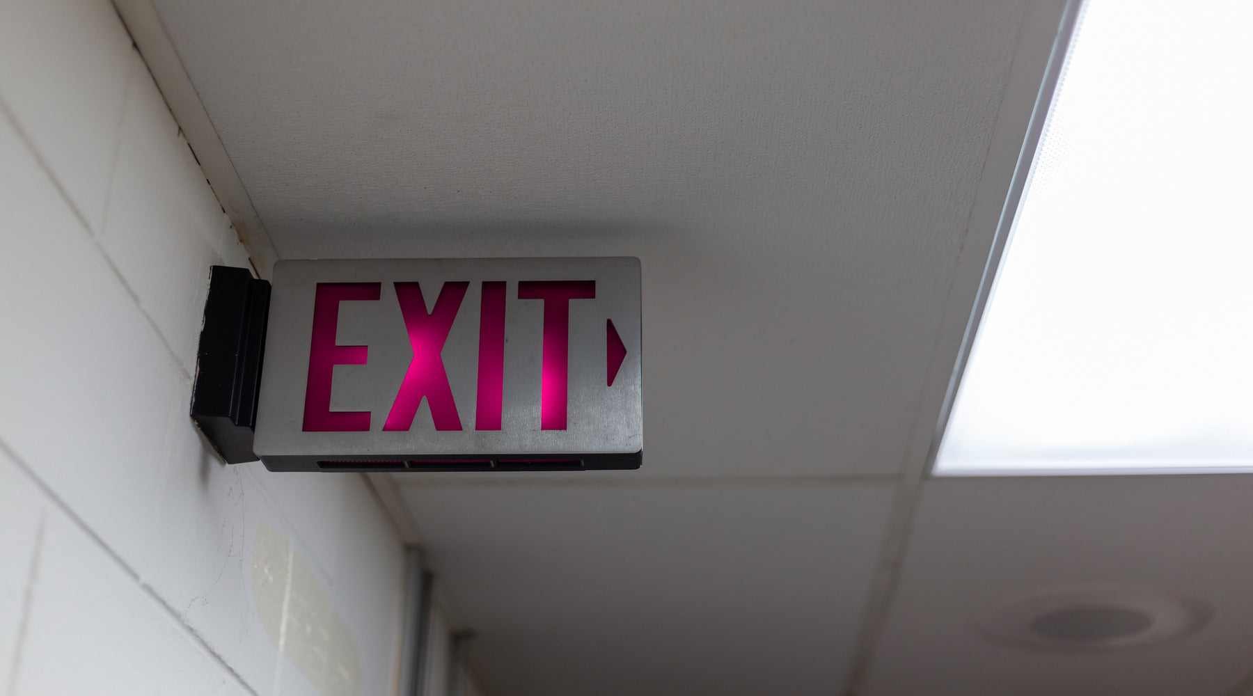 Red exit emergency light installed in office over door